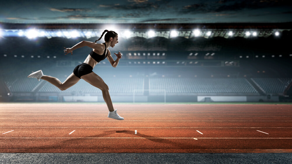 Woman running on track in an arena